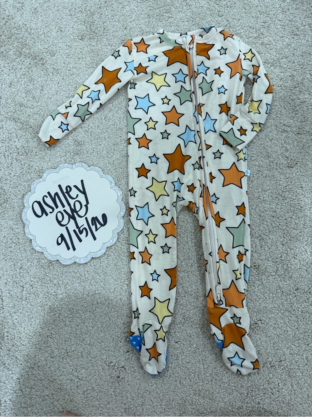 Posh Peanut Cream Footed One-Piece Pajamas with Orange, Blue & Green Stars